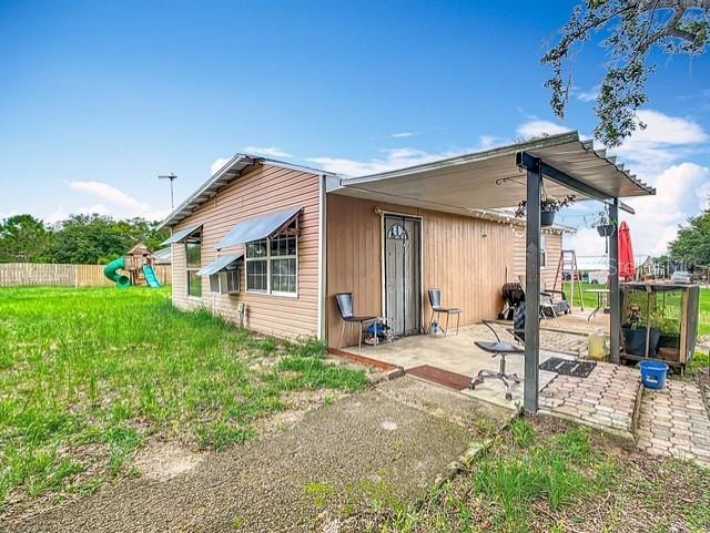 516 Petes Ln, Davenport, FL 33837 - rear view of property with a patio area and a playground