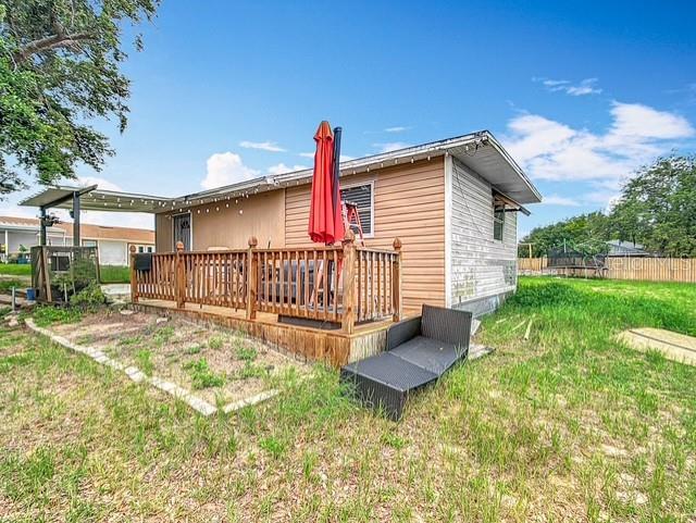516 Petes Ln, Davenport, FL 33837 - rear view of house featuring a wooden deck and a yard