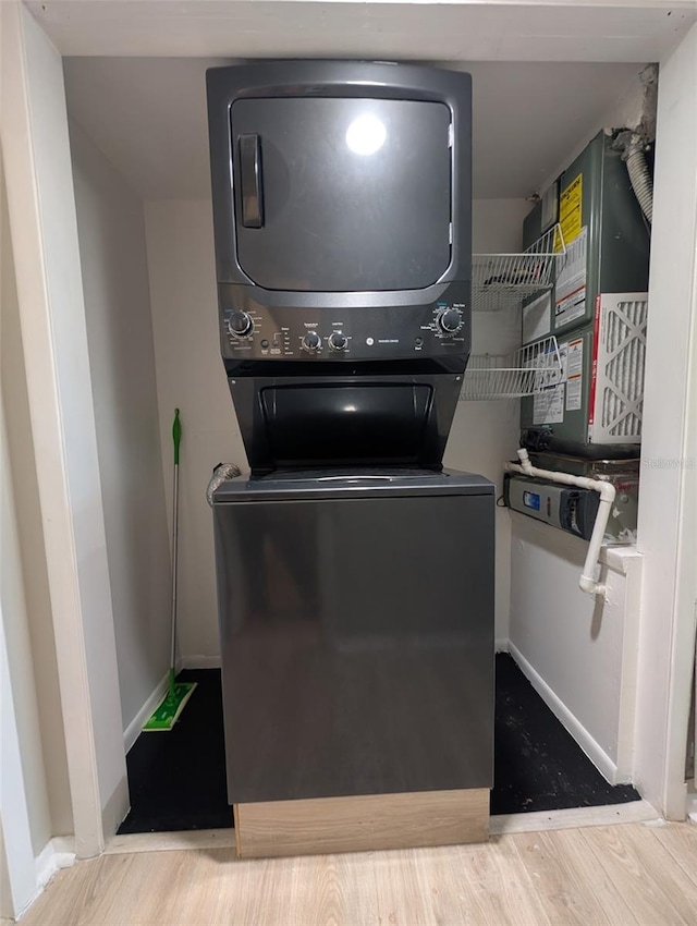 1051 S Highland St Unit 5E, Mount Dora, FL 32757 - laundry room with stacked washing machine and dryer and wood finished floors