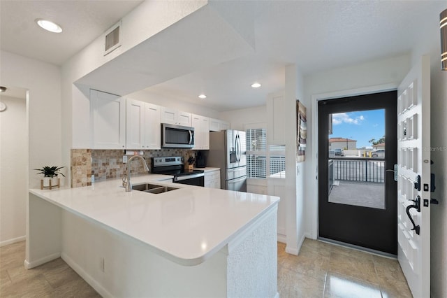 6210 Sun Blvd Unit 206, Saint Petersburg, FL 33715 - kitchen featuring stainless steel appliances, a sink, a peninsula, tasteful backsplash, and light countertops