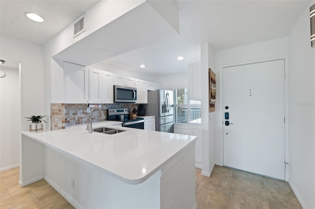 6210 Sun Blvd Unit 206, Saint Petersburg, FL 33715 - kitchen featuring appliances with stainless steel finishes, a sink, backsplash, light countertops, and white cabinets