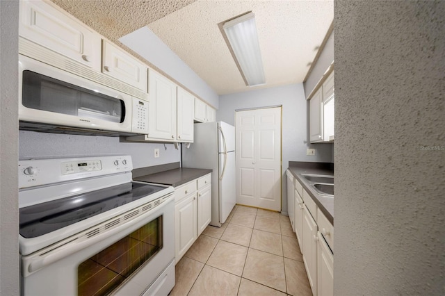 3748 Idlebrook Cir Unit 202, Casselberry, FL 32707 - kitchen with white appliances, white cabinetry, light tile patterned floors, a sink, and a textured ceiling