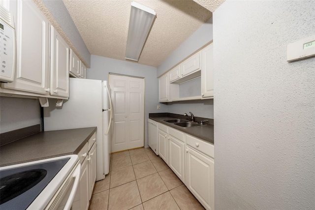 3748 Idlebrook Cir Unit 202, Casselberry, FL 32707 - kitchen featuring a sink, dark countertops, white cabinetry, light tile patterned floors, and a textured ceiling