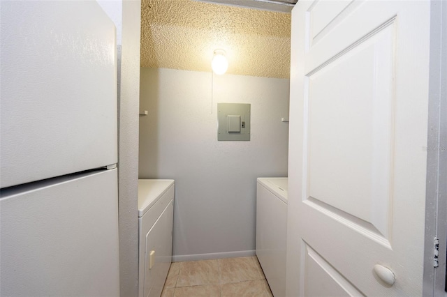 3748 Idlebrook Cir Unit 202, Casselberry, FL 32707 - washroom with washer and clothes dryer, electric panel, light tile patterned floors, baseboards, and a textured ceiling