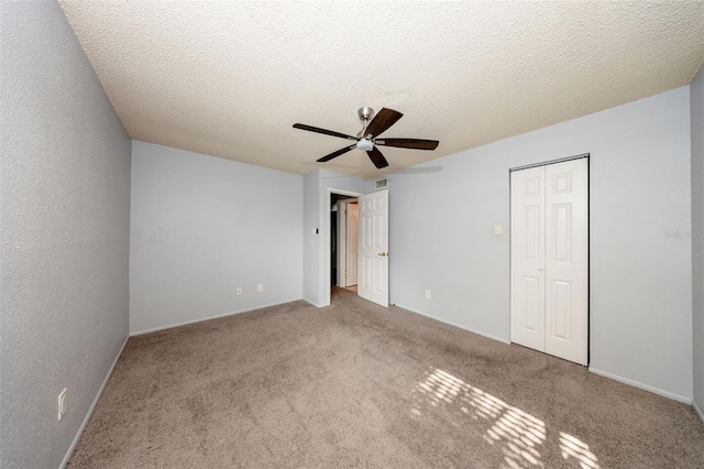 3748 Idlebrook Cir Unit 202, Casselberry, FL 32707 - unfurnished bedroom featuring a ceiling fan, a closet, carpet floors, baseboards, and a textured ceiling