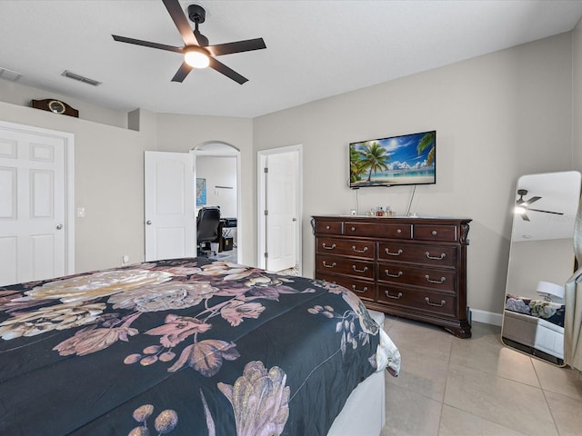 204 Cotswold Cir, Davenport, FL 33837 - bedroom with arched walkways, light tile patterned floors, ceiling fan, and baseboards
