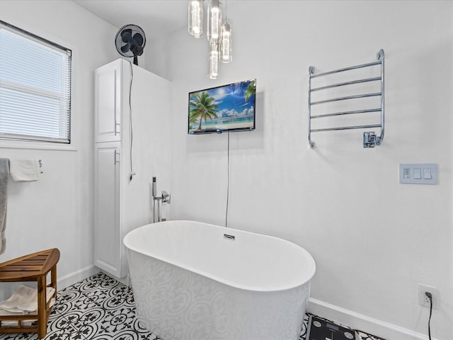 204 Cotswold Cir, Davenport, FL 33837 - bathroom with baseboards, a soaking tub, and a towel warming rack