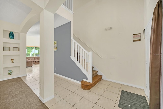8622 La Isla Dr, Kissimmee, FL 34747 - entrance foyer with arched walkways, light tile patterned floors, stairs, baseboards, and a towering ceiling