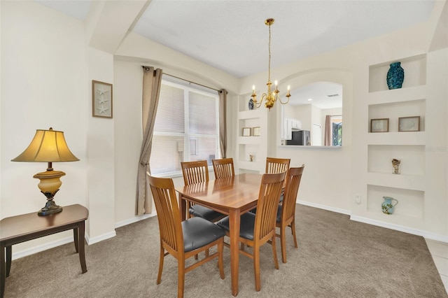 8622 La Isla Dr, Kissimmee, FL 34747 - dining space featuring a chandelier, built in features, arched walkways, and baseboards