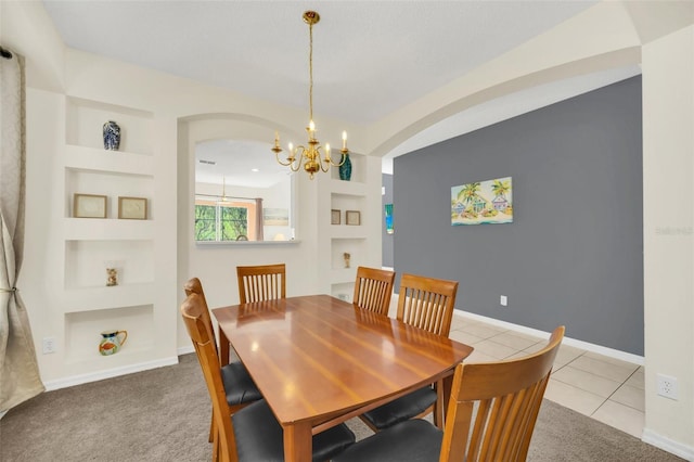 8622 La Isla Dr, Kissimmee, FL 34747 - dining area with a chandelier, built in features, arched walkways, light tile patterned flooring, and light colored carpet