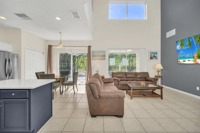 8622 La Isla Dr, Kissimmee, FL 34747 - living room featuring a towering ceiling, baseboards, light tile patterned flooring, and a textured ceiling