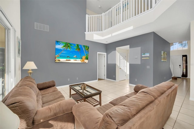 8622 La Isla Dr, Kissimmee, FL 34747 - living area with a towering ceiling, tile patterned floors, stairs, baseboards, and healthy amount of natural light