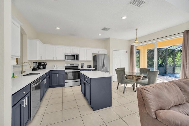 8622 La Isla Dr, Kissimmee, FL 34747 - kitchen with appliances with stainless steel finishes, open floor plan, a sink, light countertops, and white cabinetry