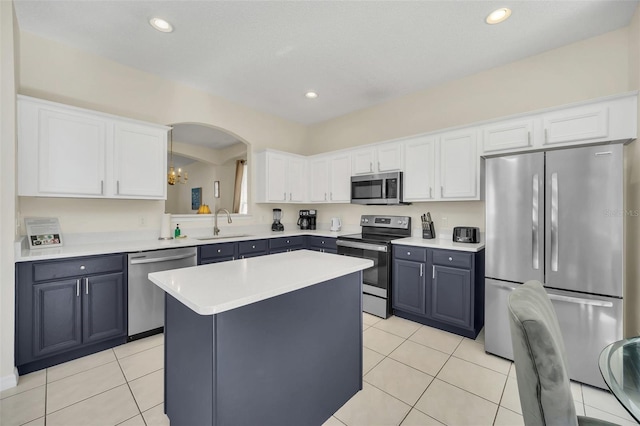 8622 La Isla Dr, Kissimmee, FL 34747 - kitchen with stainless steel appliances, a sink, light tile patterned floors, white cabinetry, and recessed lighting