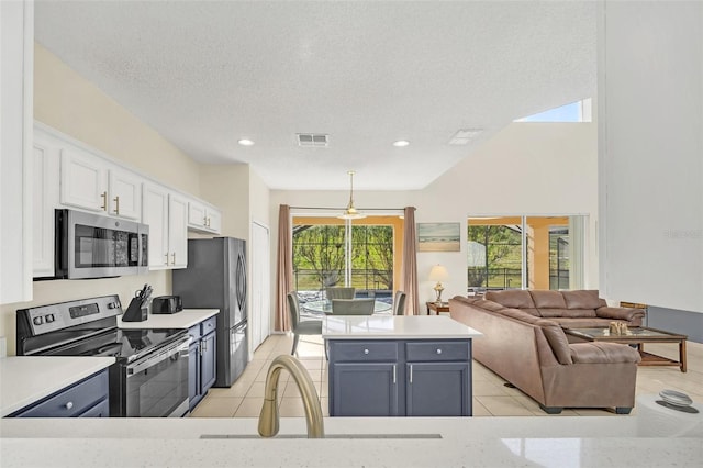 8622 La Isla Dr, Kissimmee, FL 34747 - kitchen with appliances with stainless steel finishes, white cabinetry, light countertops, a center island, and recessed lighting