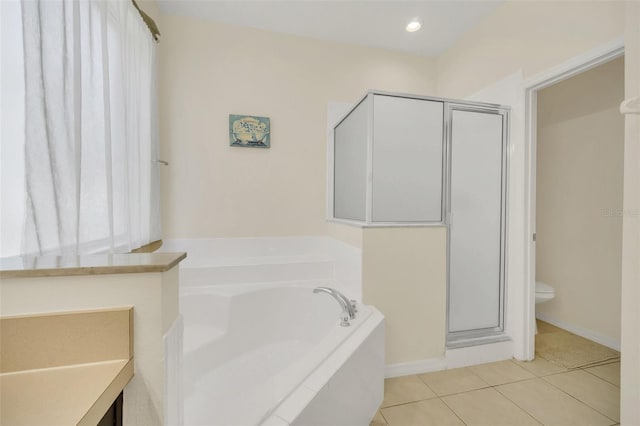 8622 La Isla Dr, Kissimmee, FL 34747 - full bathroom featuring a stall shower, a bath, toilet, and tile patterned flooring