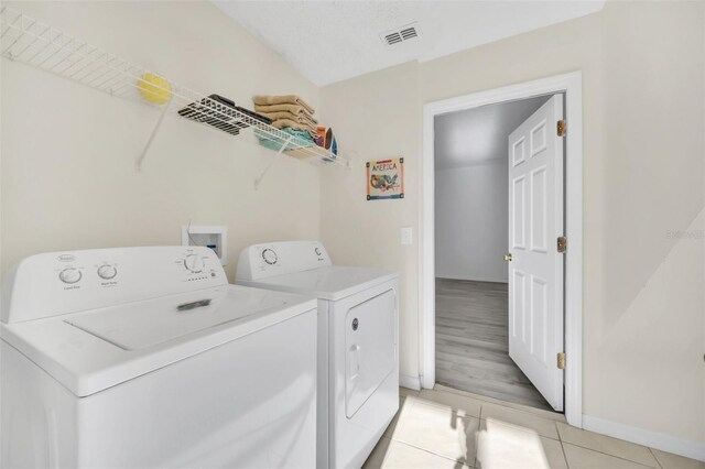 8622 La Isla Dr, Kissimmee, FL 34747 - laundry room with separate washer and dryer, light tile patterned flooring, and baseboards
