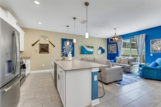 424 Ocean Course Ave, Davenport, FL 33896 - kitchen featuring appliances with stainless steel finishes, open floor plan, white cabinets, light countertops, and a kitchen breakfast bar