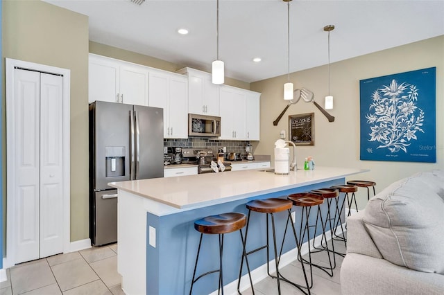 424 Ocean Course Ave, Davenport, FL 33896 - kitchen featuring appliances with stainless steel finishes, a kitchen breakfast bar, backsplash, white cabinetry, and recessed lighting