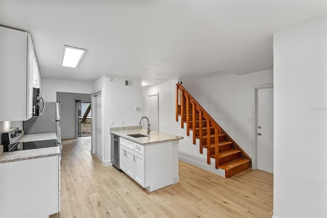131 Stefanik Rd, Winter Park, FL 32792 - kitchen with a sink, appliances with stainless steel finishes, light wood-type flooring, white cabinetry, and baseboards