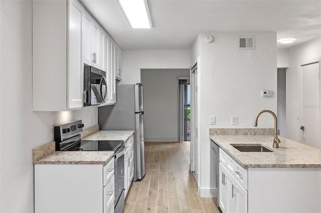 131 Stefanik Rd, Winter Park, FL 32792 - kitchen with stainless steel appliances, a sink, a peninsula, and white cabinetry
