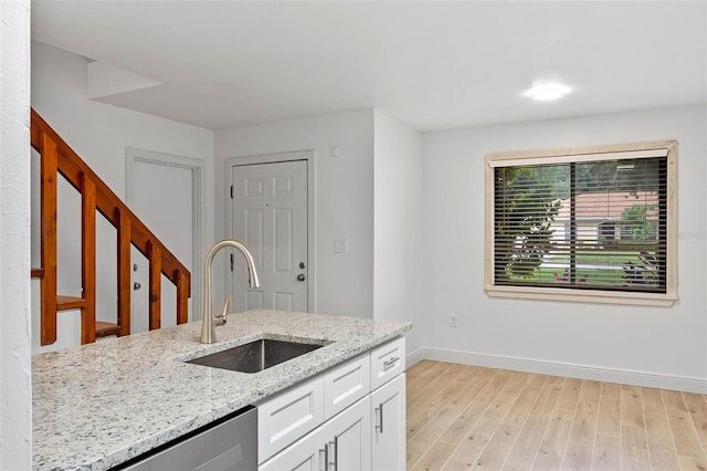 131 Stefanik Rd, Winter Park, FL 32792 - kitchen featuring a sink, baseboards, white cabinets, light stone countertops, and light wood finished floors