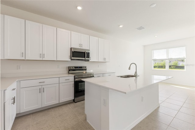 797 Lemon Ave, Fruitland Park, FL 34731 - kitchen with stainless steel appliances, a sink, light tile patterned floors, an island with sink, and light countertops