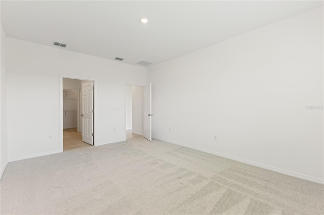 797 Lemon Ave, Fruitland Park, FL 34731 - unfurnished bedroom with light carpet, a walk in closet, baseboards, and a closet