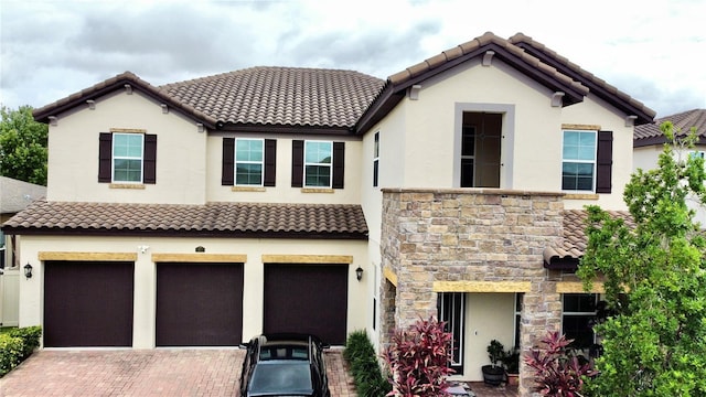 16611 Toccoa Row, Winter Garden, FL 34787 - view of front of house featuring stucco siding, an attached garage, a tile roof, stone siding, and decorative driveway