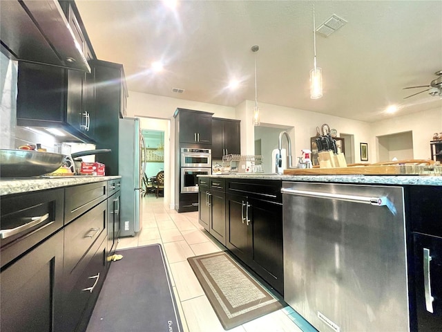 16611 Toccoa Row, Winter Garden, FL 34787 - kitchen with appliances with stainless steel finishes, pendant lighting, dark cabinets, a ceiling fan, and light tile patterned floors