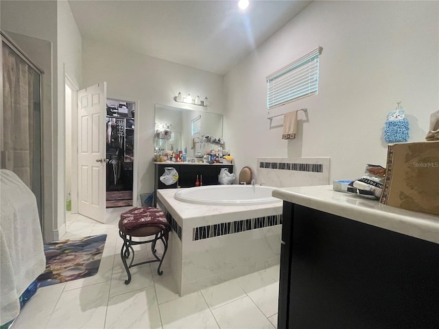 16611 Toccoa Row, Winter Garden, FL 34787 - full bathroom featuring marble finish floors, a garden tub, vanity, a shower stall, and a walk in closet