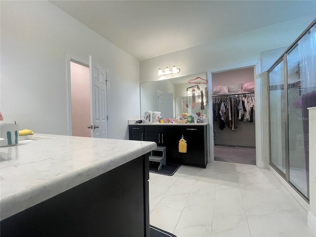 16611 Toccoa Row, Winter Garden, FL 34787 - bathroom featuring marble finish floors, vanity, a shower stall, and a spacious closet