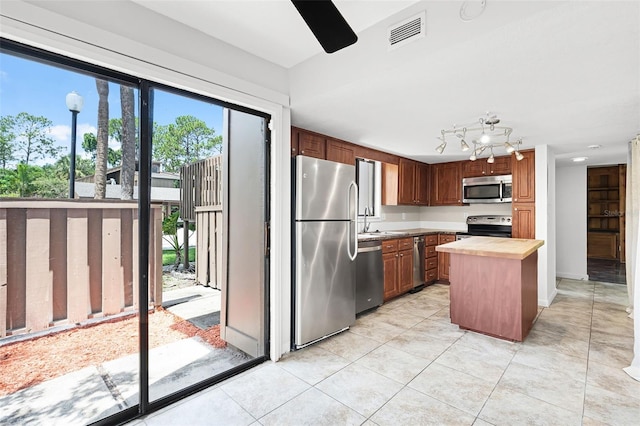 5301 Burning Tree Dr Unit F, Orlando, FL 32811 - kitchen featuring stainless steel appliances, wooden counters, and light tile patterned floors