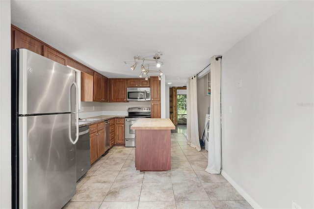 5301 Burning Tree Dr Unit F, Orlando, FL 32811 - kitchen featuring appliances with stainless steel finishes, light tile patterned floors, wood counters, and a kitchen island