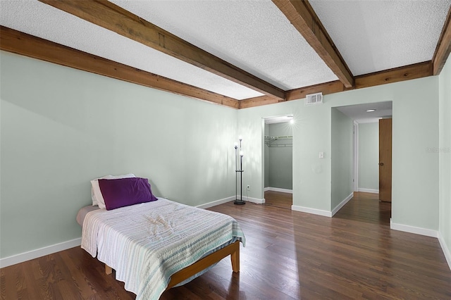 5301 Burning Tree Dr Unit F, Orlando, FL 32811 - bedroom featuring a textured ceiling, beam ceiling, and dark wood-style flooring