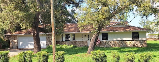 10012 Lake Louisa Rd, Clermont, FL 34711 - single story home featuring stone siding, driveway, a front lawn, a garage, and covered porch