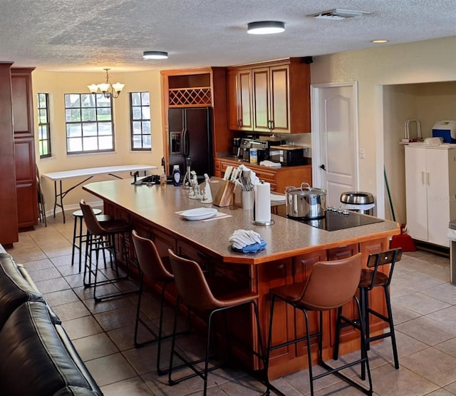 10012 Lake Louisa Rd, Clermont, FL 34711 - bar area featuring black appliances, a textured ceiling, light tile patterned flooring, a chandelier, and baseboards