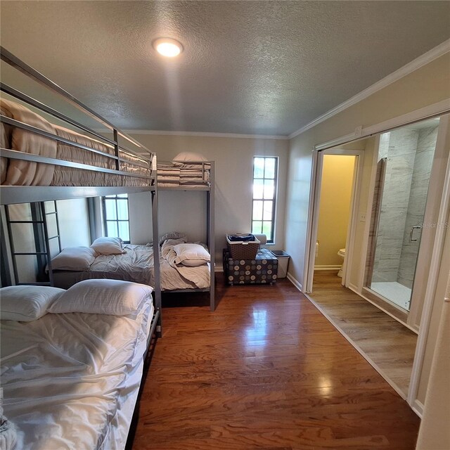 10012 Lake Louisa Rd, Clermont, FL 34711 - bedroom with a textured ceiling, ornamental molding, wood finished floors, connected bathroom, and baseboards