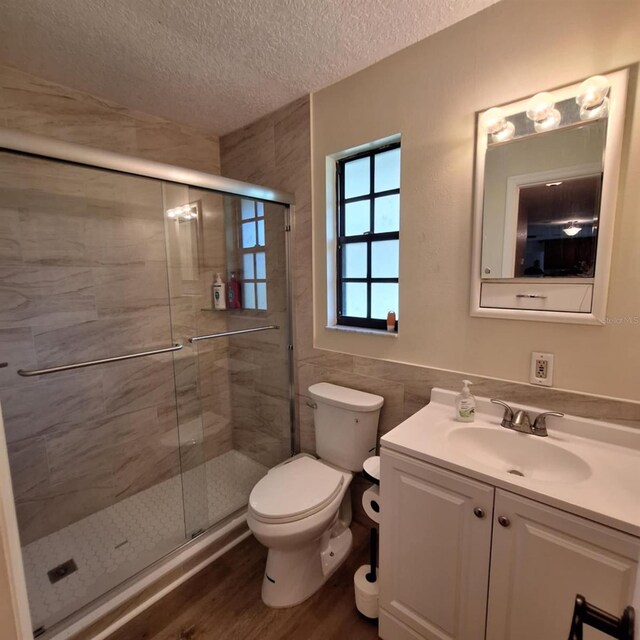 10012 Lake Louisa Rd, Clermont, FL 34711 - bathroom featuring vanity, toilet, a shower stall, a textured ceiling, and wood finished floors