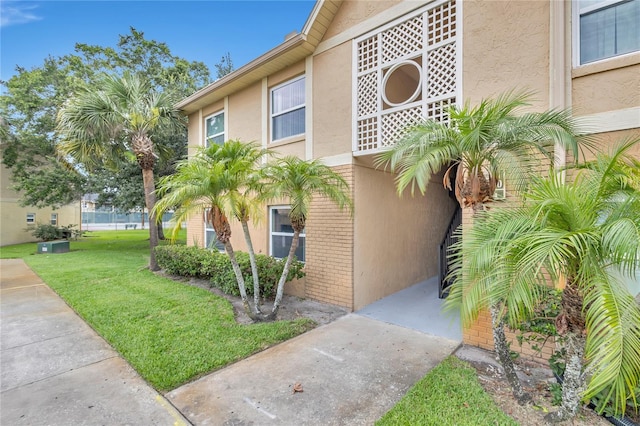9900 Sweepstakes Ln Unit 1, Orlando, FL 32837 - view of property exterior with stucco siding, brick siding, and a lawn