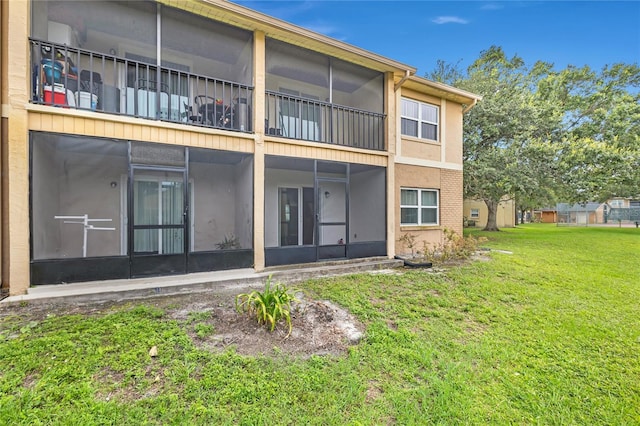 9900 Sweepstakes Ln Unit 1, Orlando, FL 32837 - rear view of house featuring a sunroom and a yard