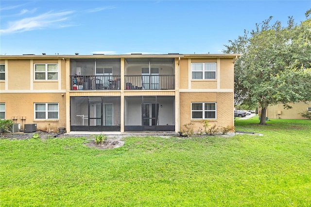 9900 Sweepstakes Ln Unit 1, Orlando, FL 32837 - back of house with a sunroom, a lawn, central AC unit, and stucco siding