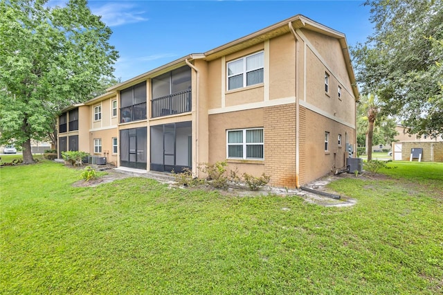 9900 Sweepstakes Ln Unit 1, Orlando, FL 32837 - rear view of house with a yard, stucco siding, central AC, and brick siding