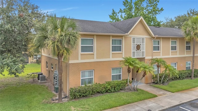 9900 Sweepstakes Ln Unit 1, Orlando, FL 32837 - view of property featuring stucco siding, a front yard, and cooling unit