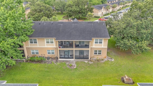 9900 Sweepstakes Ln Unit 1, Orlando, FL 32837 - back of house with a balcony, roof with shingles, stucco siding, and a lawn