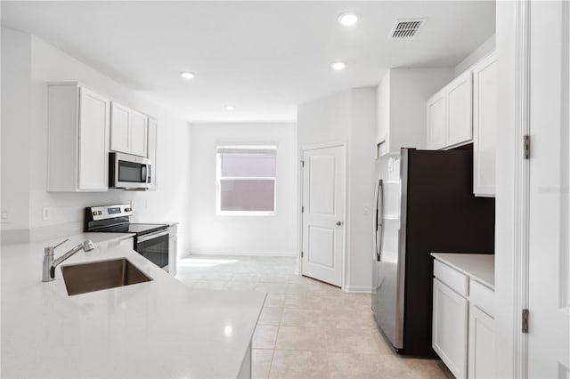 716 Daring Dr, Davenport, FL 33837 - kitchen featuring a sink, appliances with stainless steel finishes, white cabinetry, light countertops, and recessed lighting