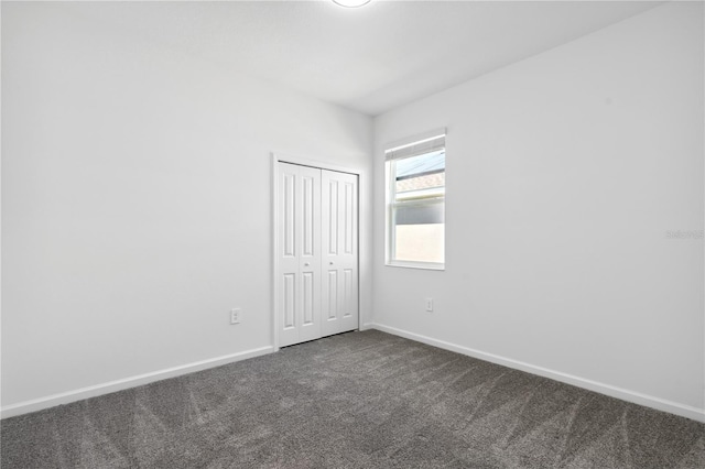 716 Daring Dr, Davenport, FL 33837 - unfurnished bedroom with dark colored carpet, baseboards, and a closet