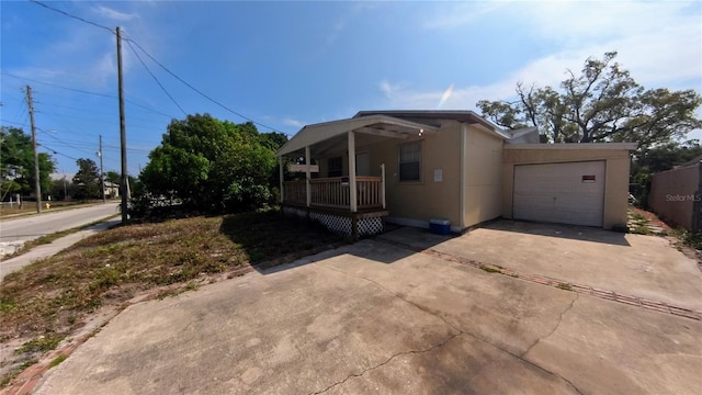 39 S College Ave, Maitland, FL 32751 - view of front facade featuring covered porch, driveway, a garage, and stucco siding
