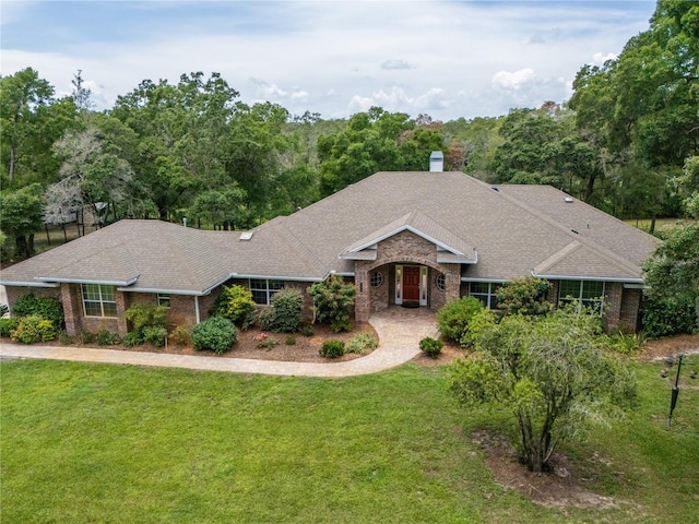 1550 Kevin Ln, Deland, FL 32724 - ranch-style house featuring a front yard, brick siding, a chimney, and a shingled roof