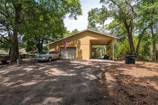 1550 Kevin Ln, Deland, FL 32724 - view of home's exterior with stucco siding, an attached garage, and dirt driveway